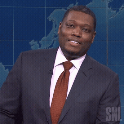 Man In Suit And Tie Standing In Front Of SNL Sign GIF