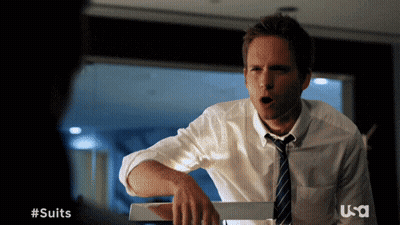Man In Suit And Tie Standing In Front Of #Suits Sign GIF