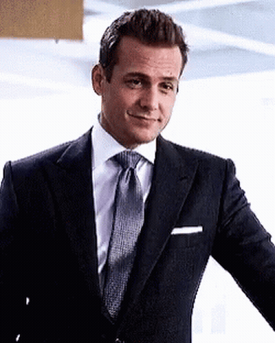 Man In Suit And Tie Standing In Front Of Wall GIF