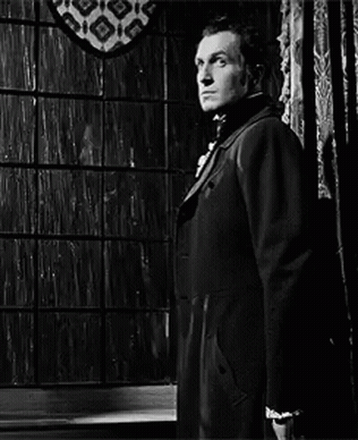 Man In Suit And Tie Standing In Front Of Window Black And White GIF