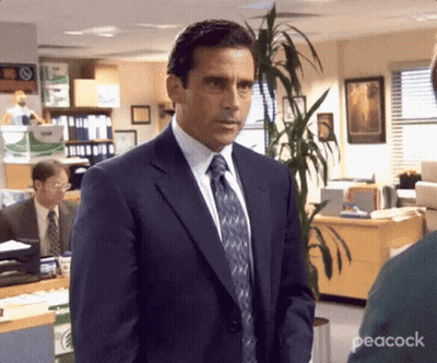 Man In Suit And Tie Standing In Office With Plant GIF