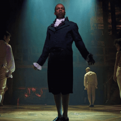 Man In Suit And Tie Standing On Stage GIF