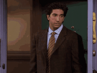 Man In Suit And Tie Standing With Arms Out GIF