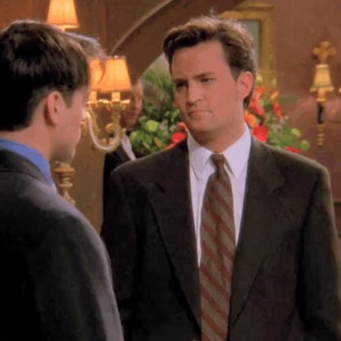 Man In Suit And Tie Talking To Man In Blue Shirt GIF