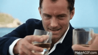 Man In Suit And Tie Toasting With Two Glasses Of Wine GIF
