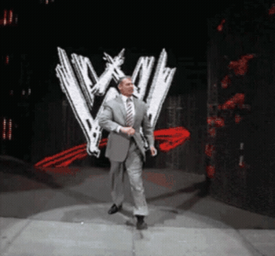 Man In Suit And Tie Walking Past WWE Logo GIF