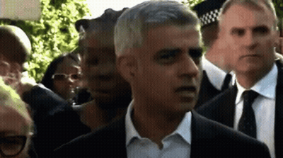 Man In Suit And Tie Walking Through Crowd GIF