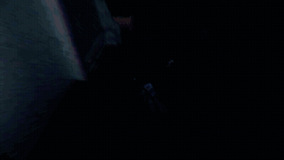 Man In Suit And Tie Walking Through Dark Room GIF