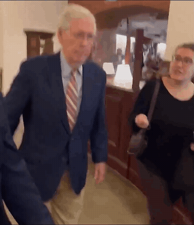 Man In Suit And Tie Walking With Woman In Black Shirt GIF