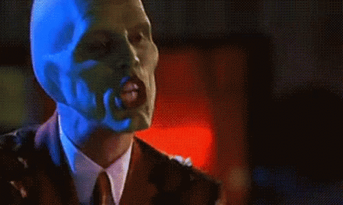 Man In Suit And Tie Wearing Mask GIF