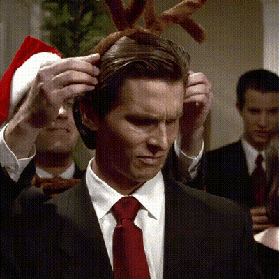 Man In Suit And Tie Wearing Reindeer Antlers GIF