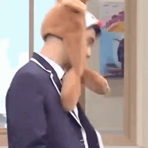 Man In Suit And Tie Wearing Stuffed Animal Hat GIF