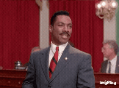 Man In Suit And Tie With Arms In The Air In Front Of Crowd GIF