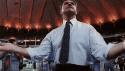Man In Suit And Tie With Arms Outstretched In Stadium GIF