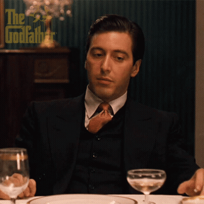 Man In Suit And Tie With The Godfather Poster GIF