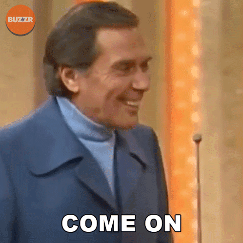 Man In Suit And Turtleneck Smiling Saying Come On GIF