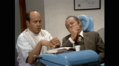Man In Suit And White Coat Looking At Book GIF