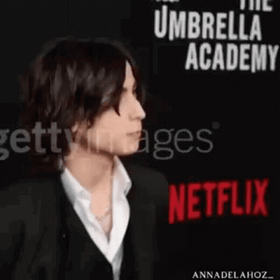 Man In Suit And White Shirt At Netflix Sign GIF