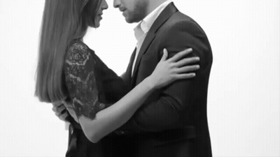 Man in Suit and Woman in Black Dress Hugging