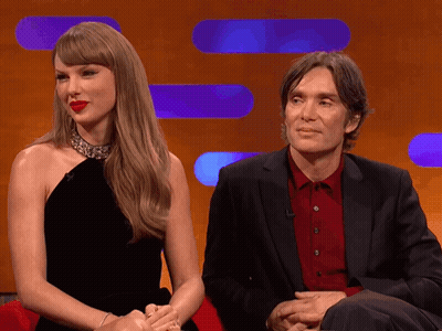 Man In Suit And Woman In Black Dress Sitting GIF