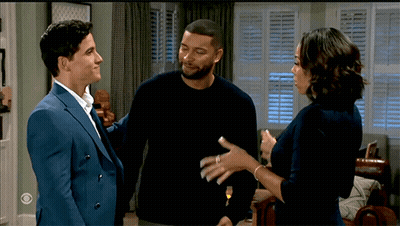 Man In Suit And Woman In Black Sweater Talking In Living Room GIF