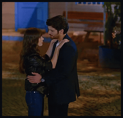 Man In Suit And Woman In Jacket Kissing GIF