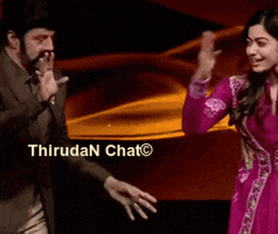Man In Suit And Woman In Pink Dress Dancing Before Thirudan Chat Sign GIF