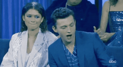 Man In Suit And Woman In White Jacket Sitting With ABC GIF