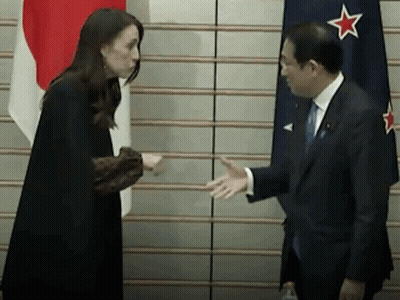 Man In Suit And Woman Shaking Hands By Flag GIF