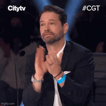 Man In Suit Applauding At Microphone GIF