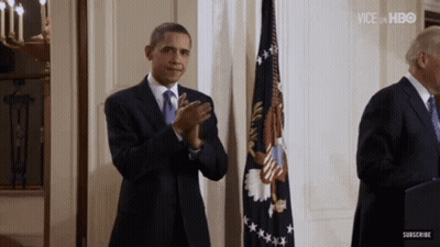 Man In Suit Applauding In Front Of Flag GIF