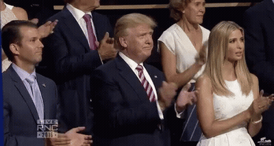 Man In Suit Applauding While Woman In White Dress Watches GIF