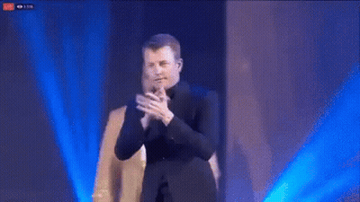 Man In Suit Applauding With Another Man Behind GIF