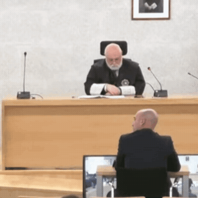 Man In Suit At Courtroom Desk GIF