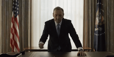 Man In Suit At Desk In Front Of Window GIF