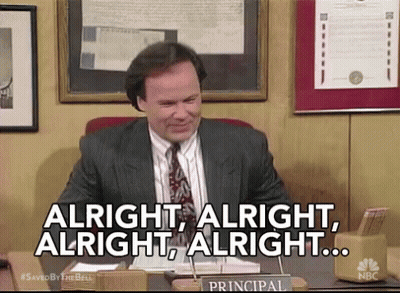Man In Suit At Desk Saying Alright GIF