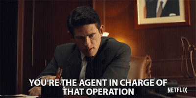 Man In Suit At Desk Says You're The Agent In Charge GIF