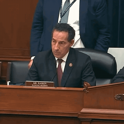 Man In Suit At Desk With Mr. Raskin Name Tag GIF