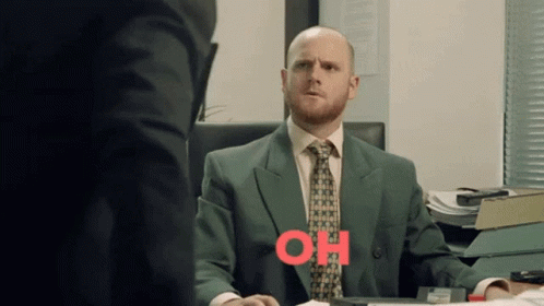 Man In Suit At Desk With Oh Written In Red GIF