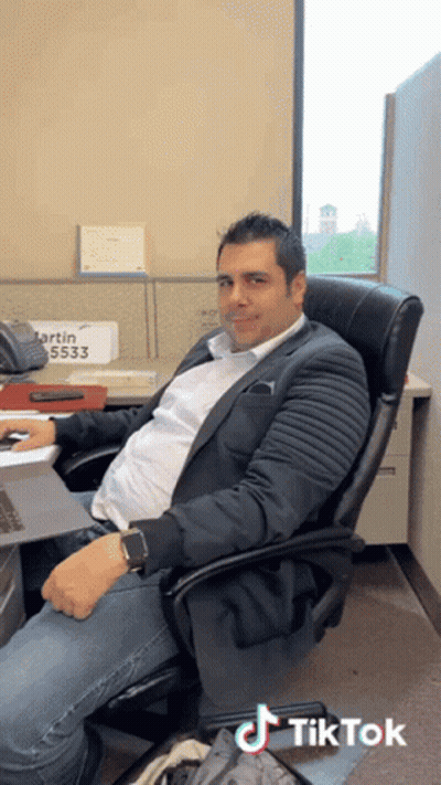 Man In Suit At Desk With Sign Martin 5533 GIF
