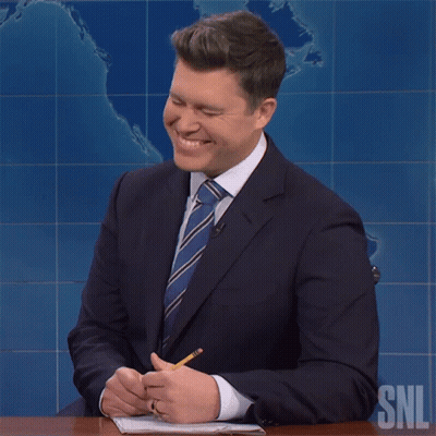 Man In Suit At Desk With SNL Logo GIF