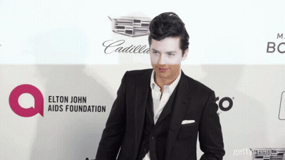 Man In Suit At Elton John AIDS Foundation Banner GIF