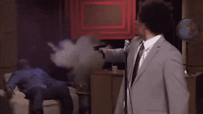Man In Suit At Mic Man On Couch GIF
