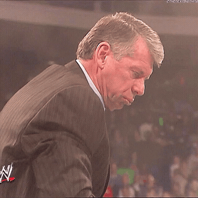 Man In Suit At Microphone In Crowd GIF