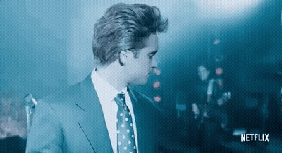 Man In Suit At Microphone In Dark Room GIF