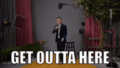 Man In Suit At Microphone Saying Get Outta Here GIF