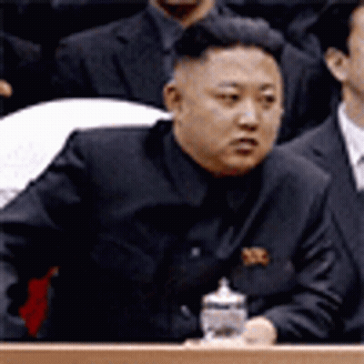 Man In Suit At Podium Holding Bottle GIF