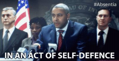 Man In Suit At Podium In An Act Of Self-Defense GIF