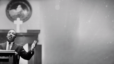 Man In Suit At Podium With Hands Outstretched GIF