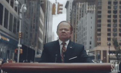 Man In Suit At SNL Podium GIF